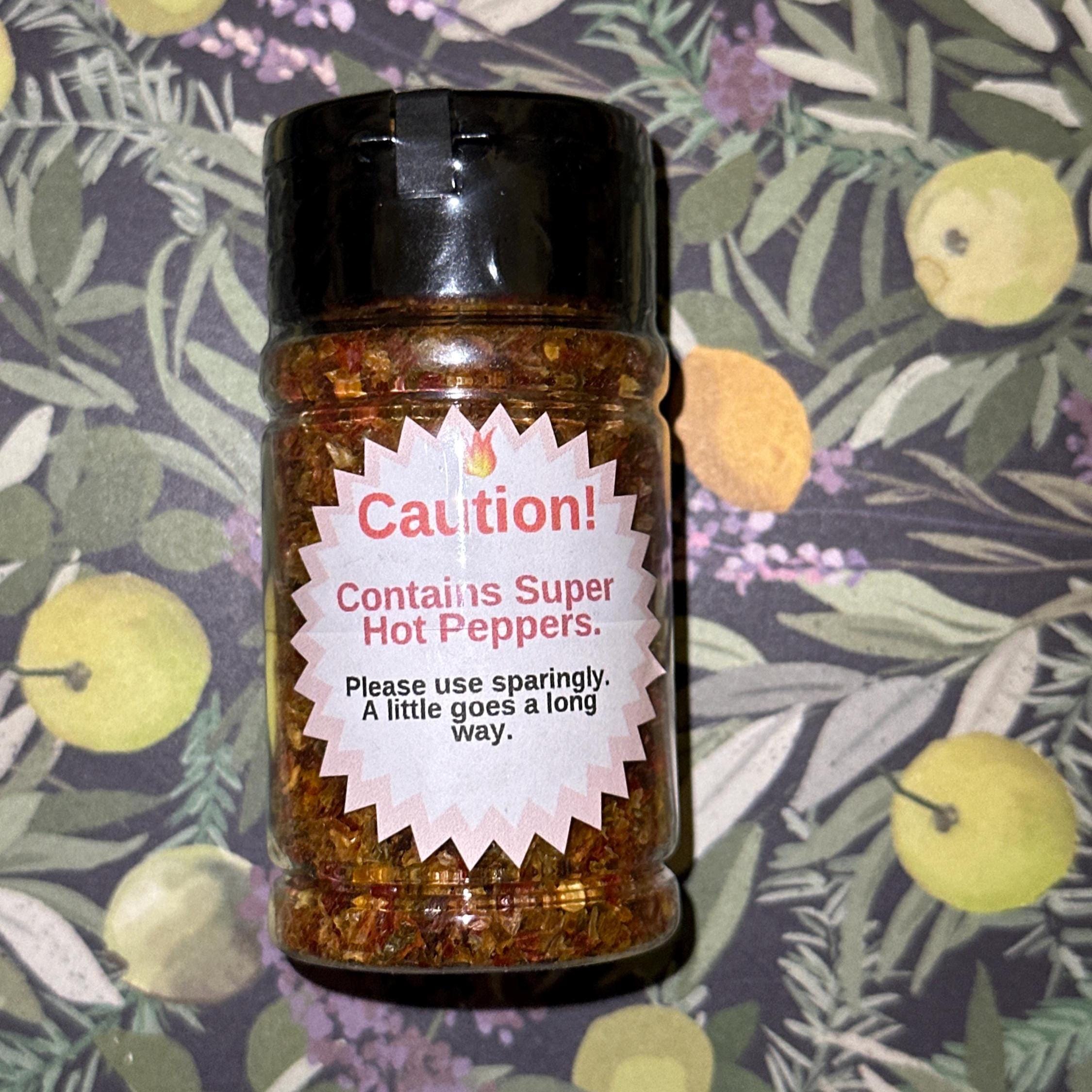 Mike’s Pepper Seeds hot pepper flake Jar of super hot peppers with a caution label on a patterned background