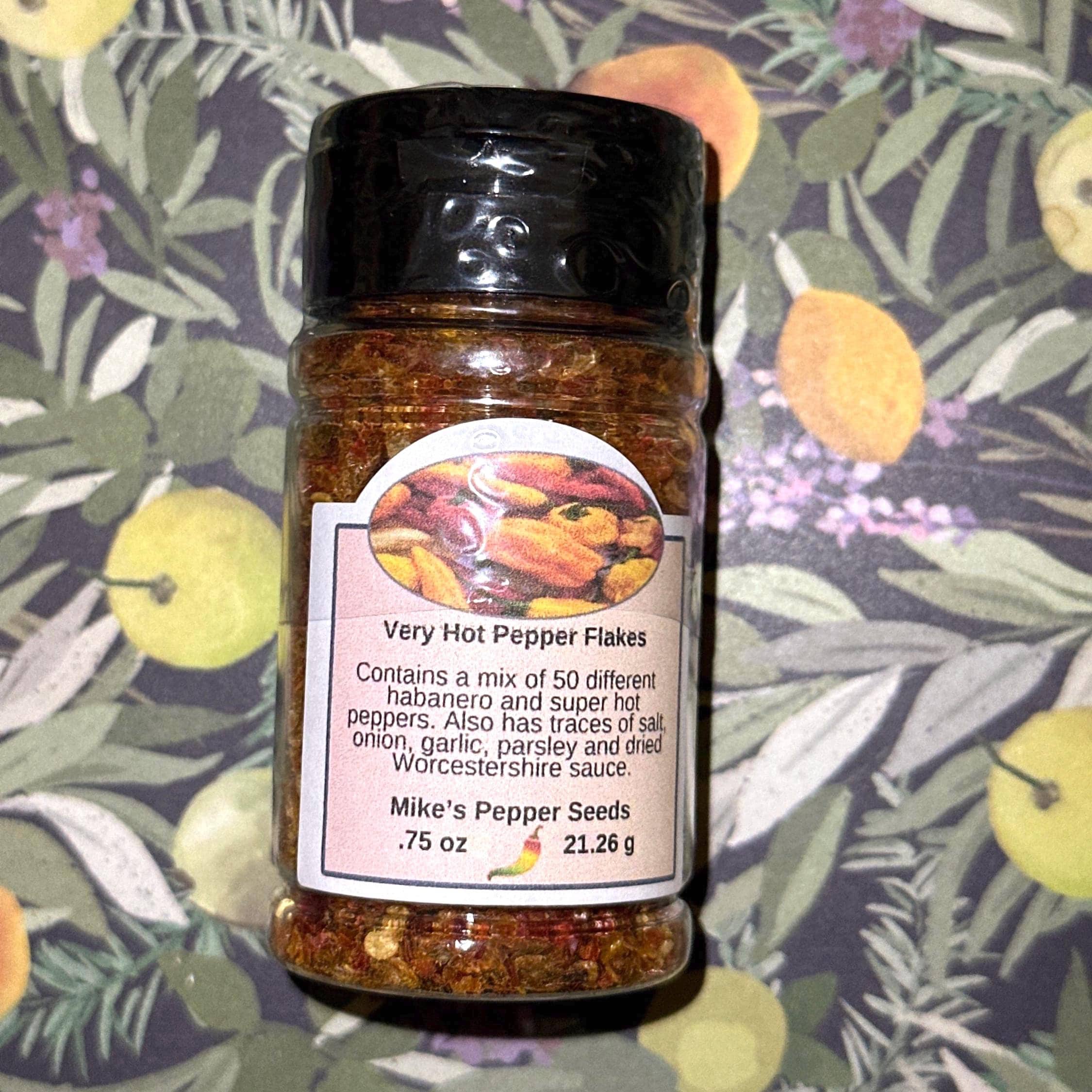 Mike’s Pepper Seeds Jar of very hot pepper flakes with a label on a floral background